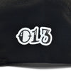 Detalhe do boné five panel preto com tecido canelado e número 013 estilizado em branco centralizado.