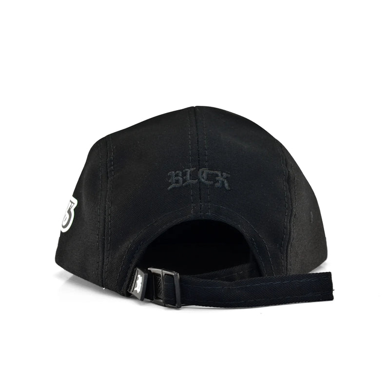 Boné five panel preto, tecido liso, letras BLCK bordadas atrás, número 013 em branco na lateral e fecho ajustável.