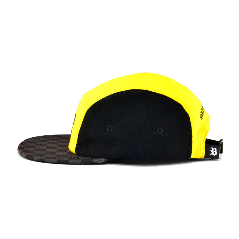Boné five panel amarelo com laterais pretas, aba xadrez escura.