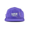 Boné five panel roxo com logo Chorão Sunset House centralizado em branco na frente. Produto para moda casual.