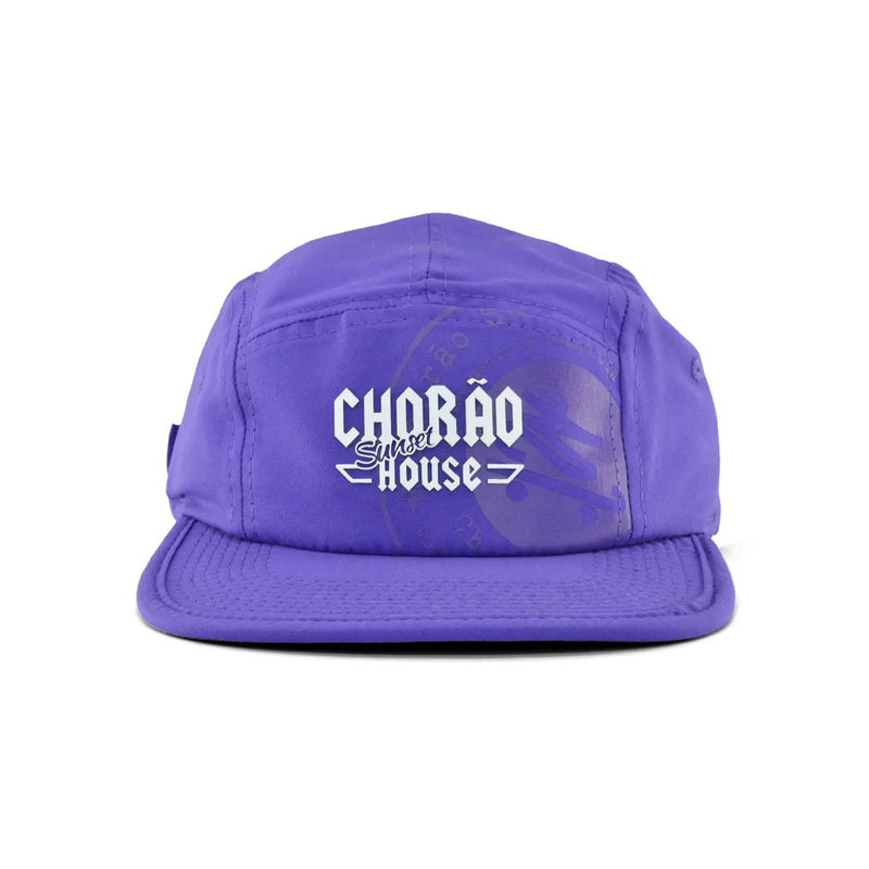 Boné five panel roxo com logo Chorão Sunset House centralizado em branco na frente. Produto para moda casual.