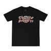 Camiseta preta com design gráfico em destaque no peito, escrita "Charlie Brown Jr", fonte estilizada laranja com detalhes brancos.