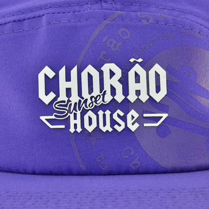 Boné five panel roxo com logo Chorão Sunset House centralizado em branco na parte frontal. 