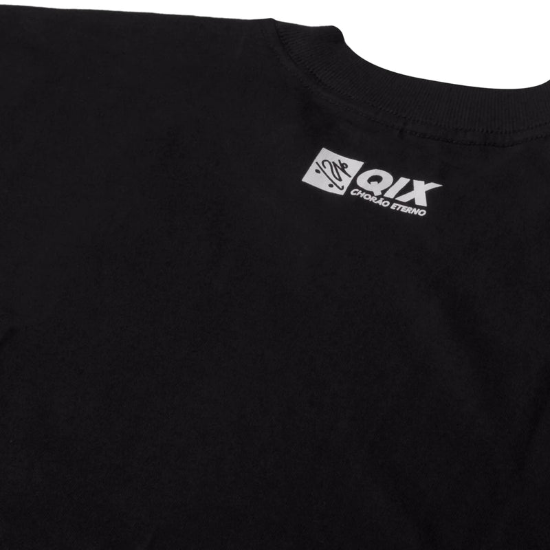 Close do logo próximo à gola na parte de trás da camisa oversized.