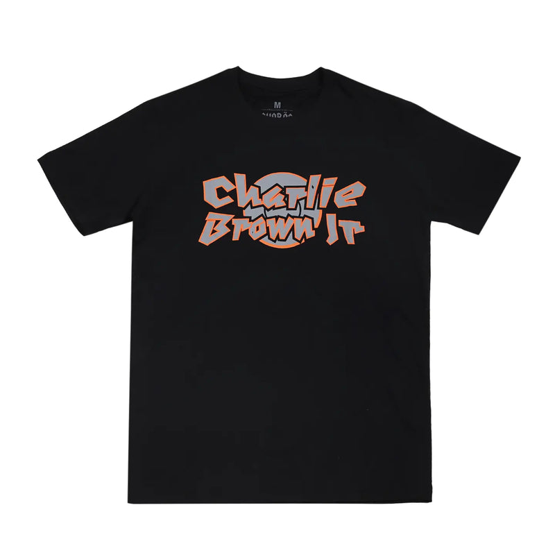 Camiseta preta com design gráfico em destaque no peito, escrita "Charlie Brown Jr", fonte estilizada laranja com detalhes brancos.
