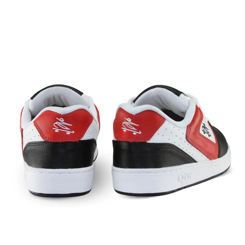Parte de trás do tênis qix Chorão park com detalhes em vermelho e preto e arte bordada em branco.