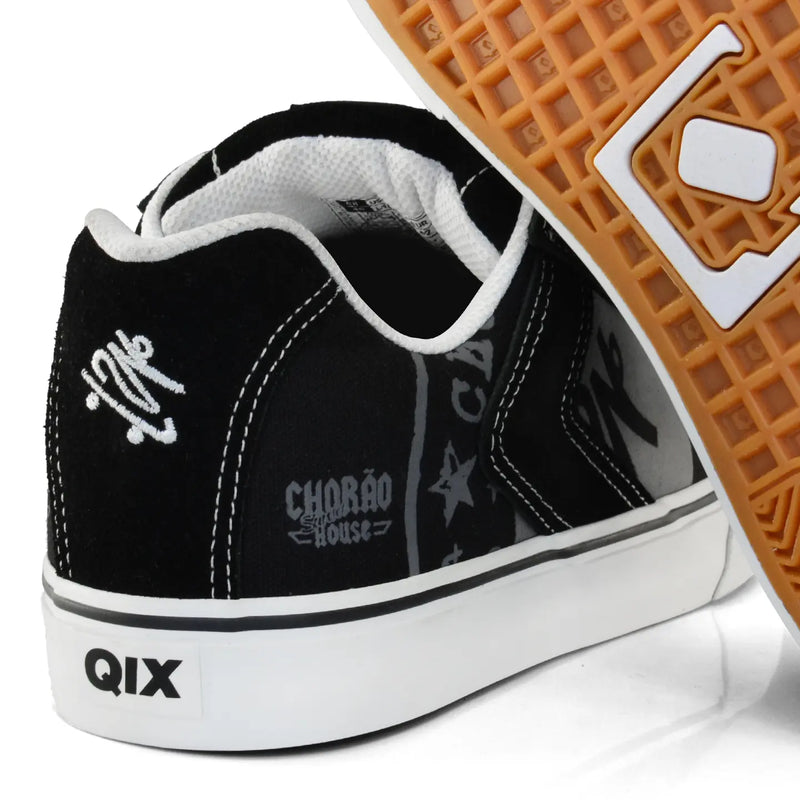 Imagem detalhada da parte de trás do tênis qix Chorão, com boneco skatista bordado em branco.
