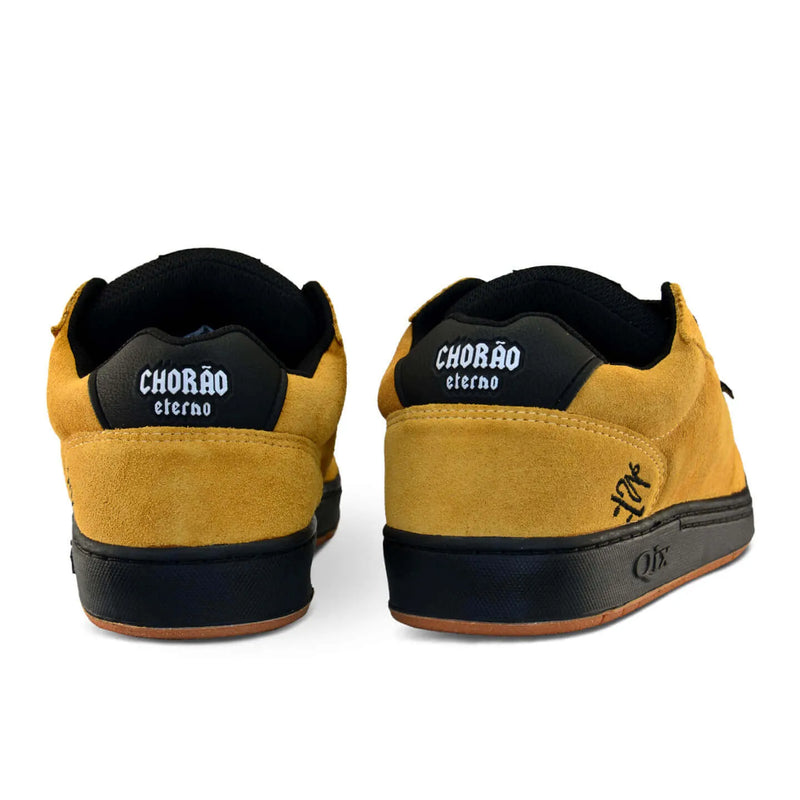Parte de trás do par de tênis qix Chorão park pro model Allan Mesquita nas cores mostarda e preto.